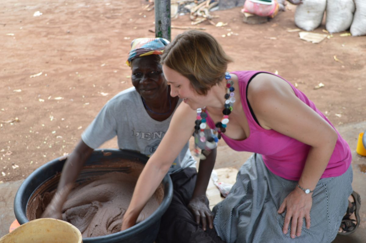 Caucasian woman helping African woman make shea butter