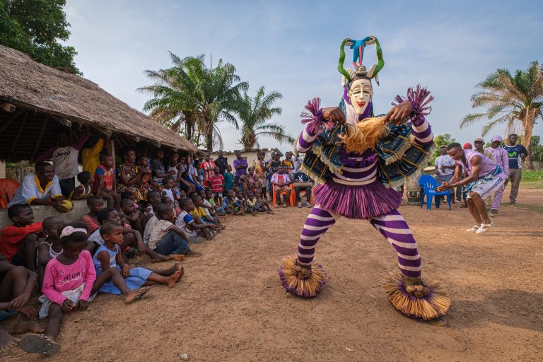 Masked Zaouli dancer performing for children